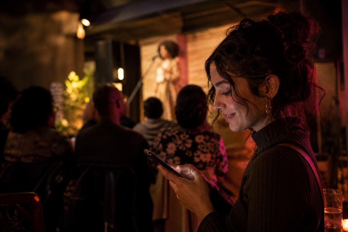 A fan connecting on her phone at a live performance